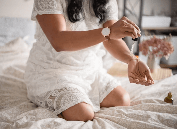 Femme en robe blanche assise sur le lit liée à une discussion sur l'hyperpigmentation